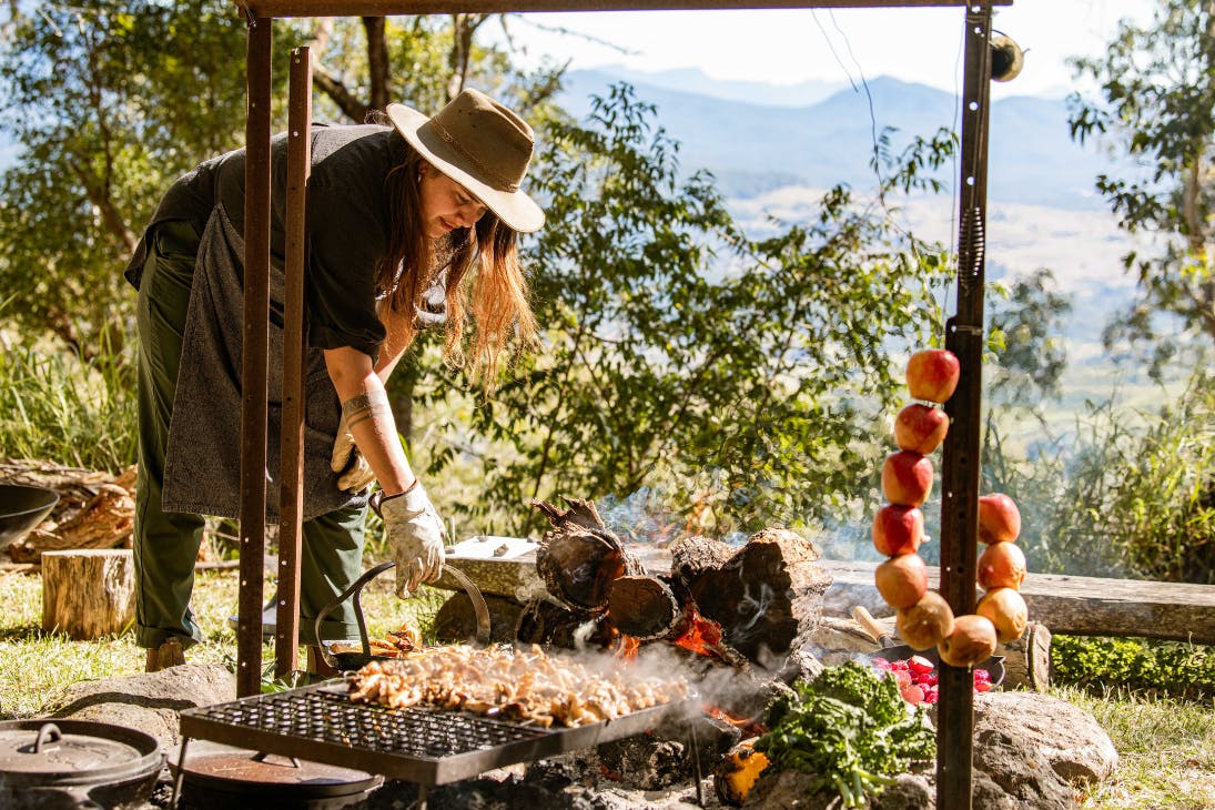 Woman cooking over a campfire